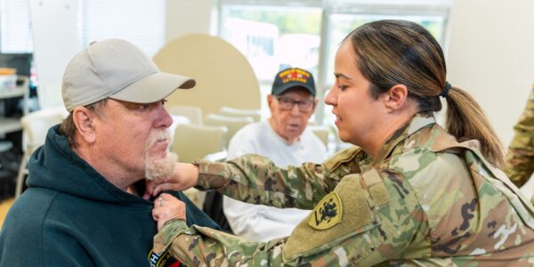 Navy Veteran and Care Resources Participant Larry receives pin from Chief Warrant Officer 2 Krista Gebhard with the Army National Guard_WEB