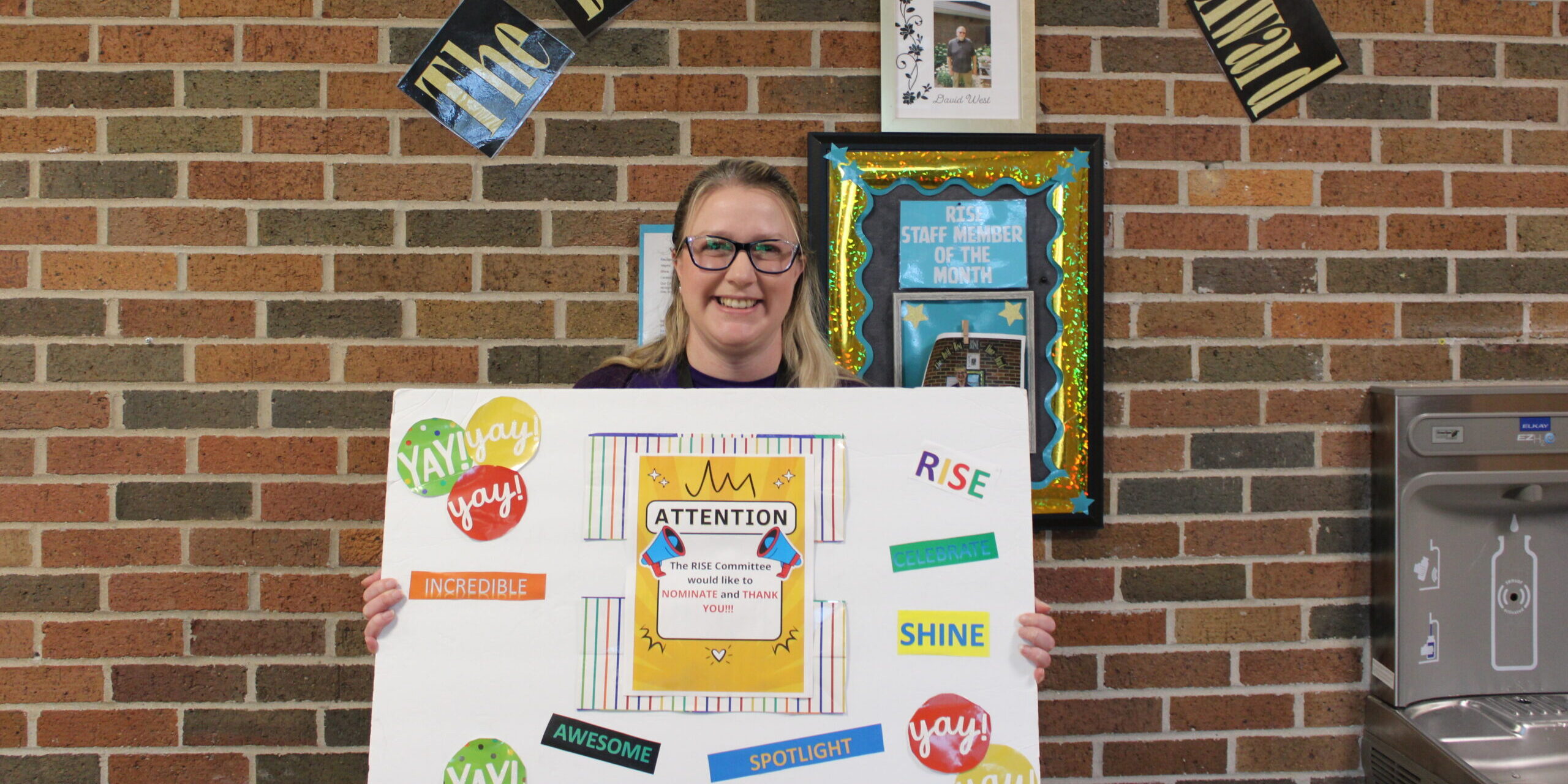 Care Resources team member holding a RISE award sign