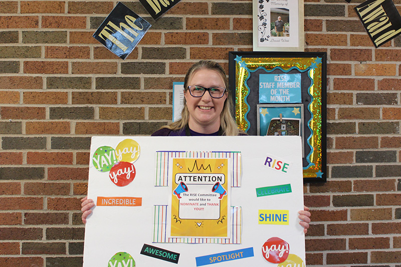 Care Resources team member holding a RISE recipient sign